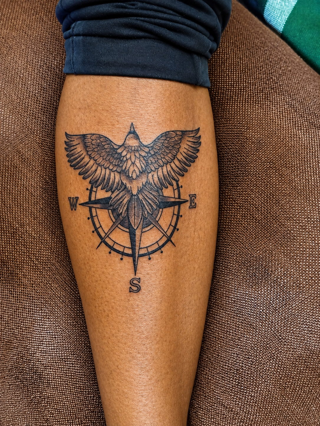Black and grey eagle and compass calf tattoo by Jay at Inking Tattoos in Limuru, Kenya